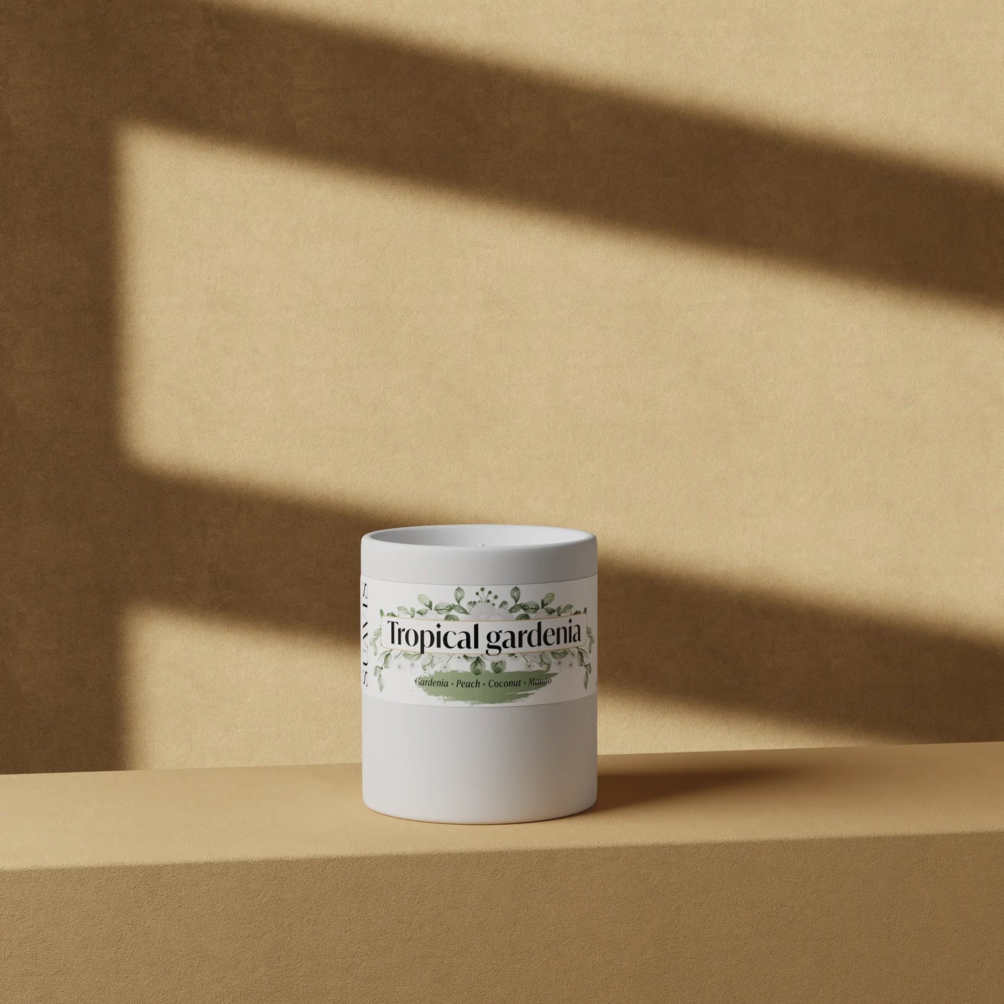 Tropical Gardenia Scented Candle in a 12oz White Ceramic vessel in front of a wall.